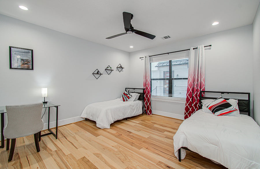 Flexible and comfortable third bedroom featuring two twin beds, ideal for additional guests, children, or traveling colleagues. Includes a dedicated desk and workspace for remote work, making it perfect for long-term stays, studying, or working from home in a quiet and functional environment.