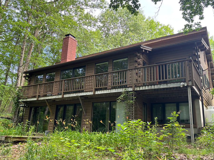 Back of home faces the forest and has banks of large windows
