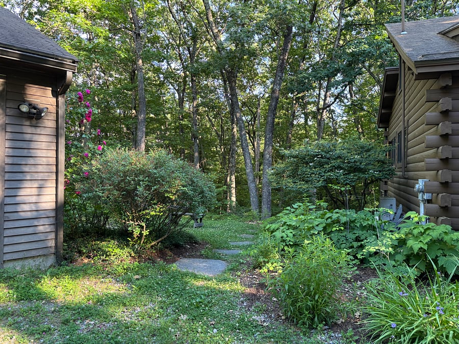 Stone pathway between garage and home leads to the suite's private entrance.