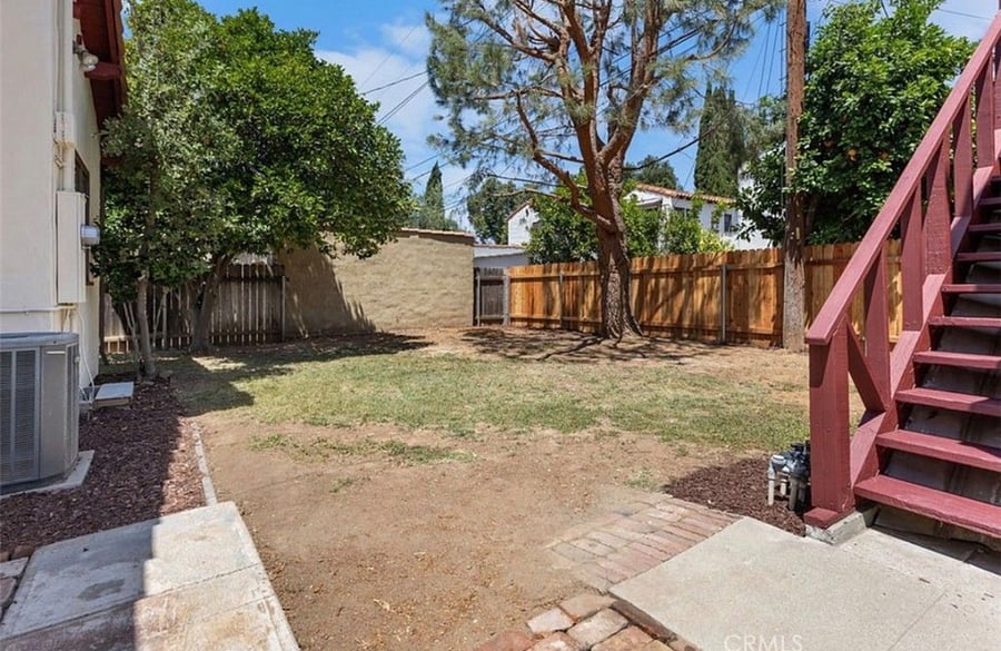 View of the backyard and red stairs to the entrance. 