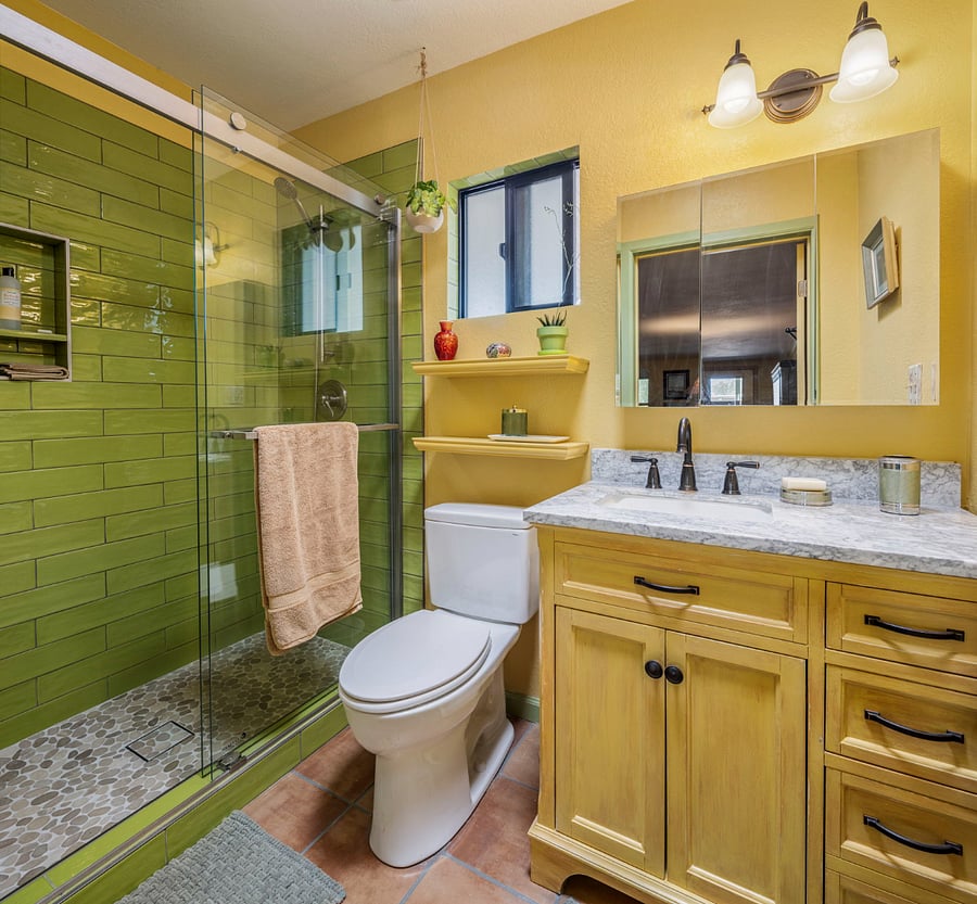 Remodeled bathroom with glass-enclosed tile shower