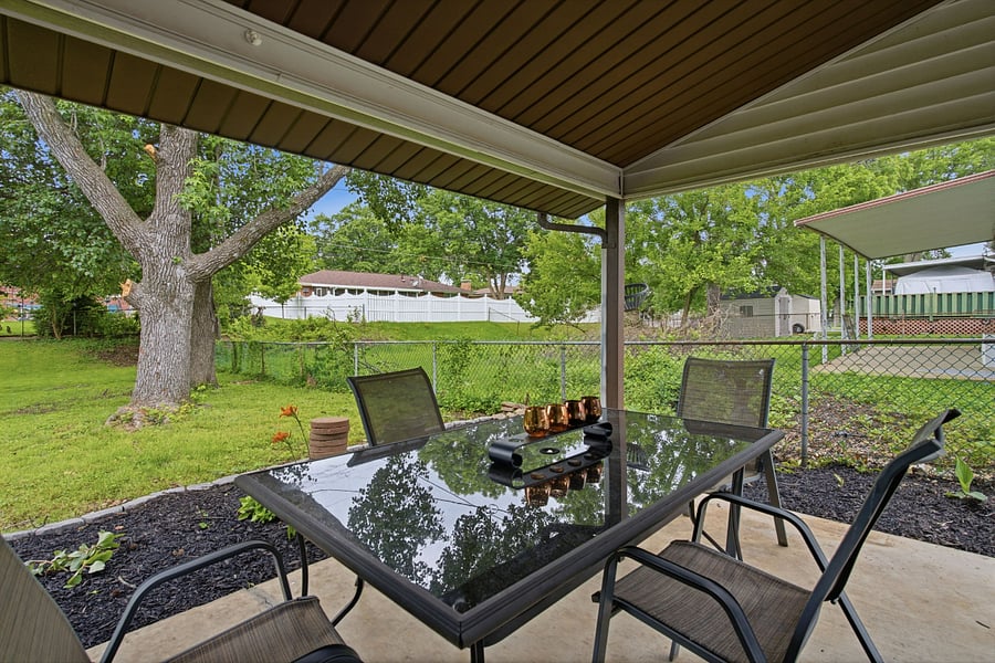 huge covered back patio with tables, chairs