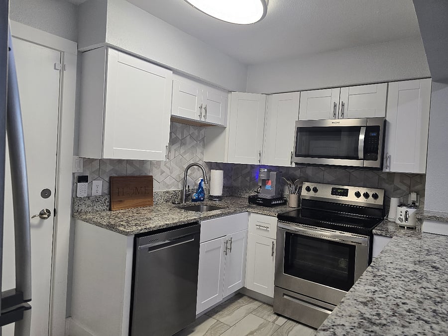 Fully stocked kitchen with cookware, dishes, utensils, glassware, and baking essentials.
