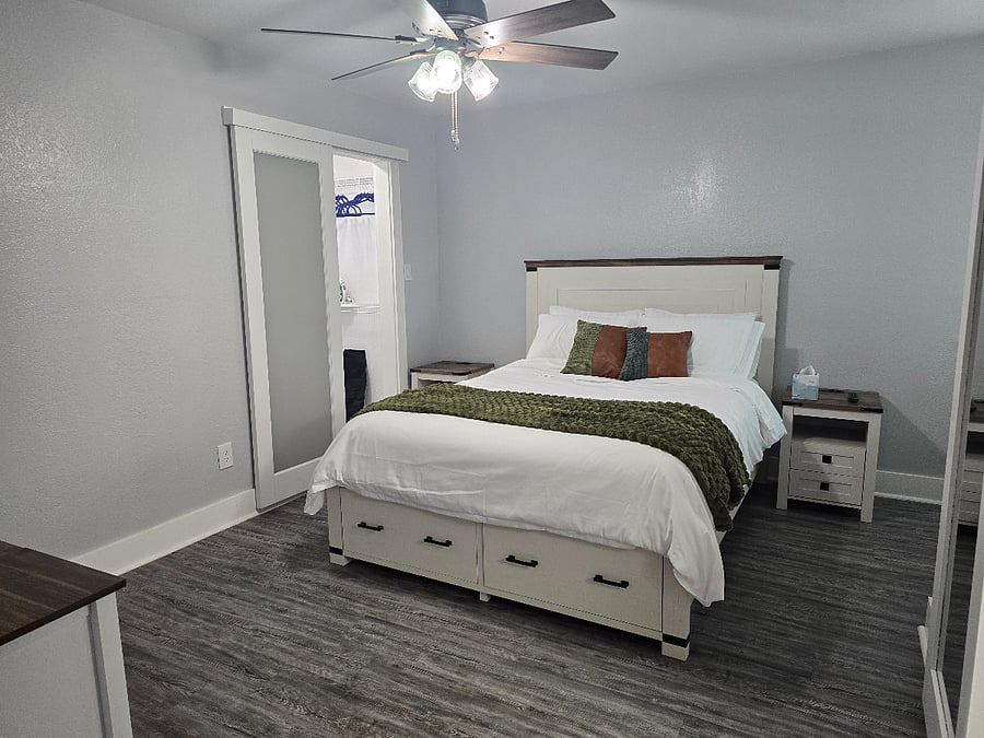Spacious primary suite with a queen bed, premium bedding, walk-in closet and large Smart TV.
