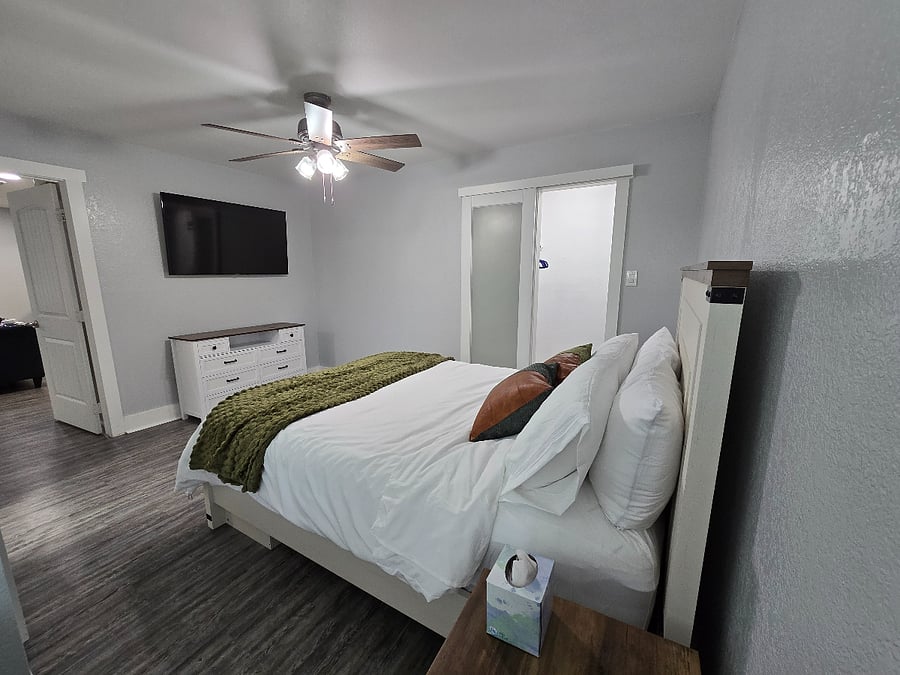 Spacious primary suite with a queen bed, premium bedding, walk-in closet and large Smart TV.