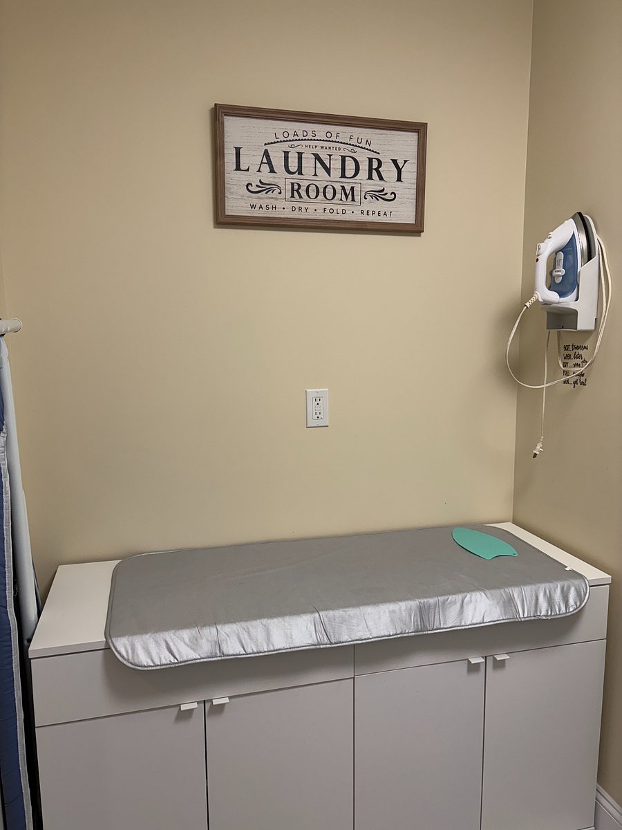 Convenient laundry area with folding space and iron.