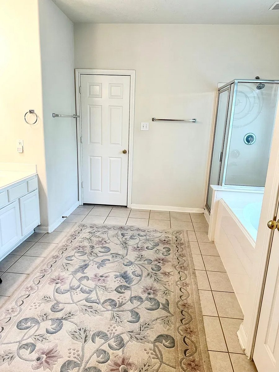Spacious private bathroom with double sinks, whirlpool tub, separate stand-up shower, and enclosed toilet area.