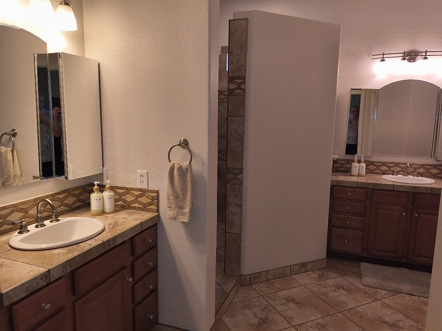 Primary bath with dual vanities, walk-in shower, separate toilet room, and walk-in closet.