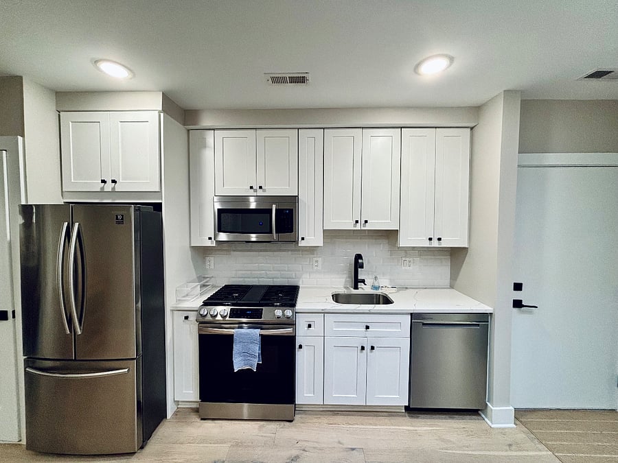 Kitchen area with large refrigerator, microwave, gas range and oven, dishwasher