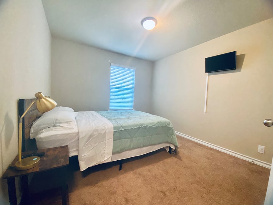 Upstairs bedroom 1 with TV and queen bed