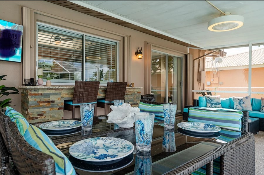 large lanai with bar b q grill and seating.