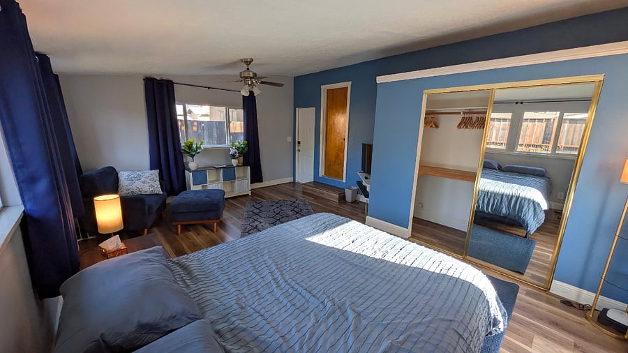 Queen bed and mirrored closet with hanging space, shelving, and provided hangers.