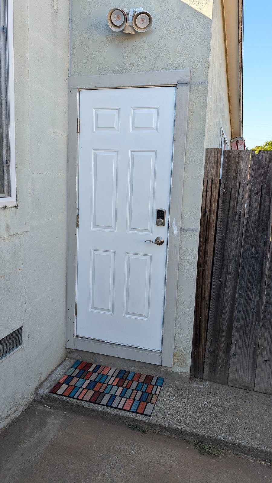 Private exterior entrance with keypad access, security light, and dedicated entry mat.