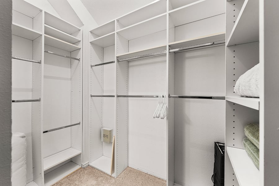 Walk-in closet with shelves and racks to hang clothes