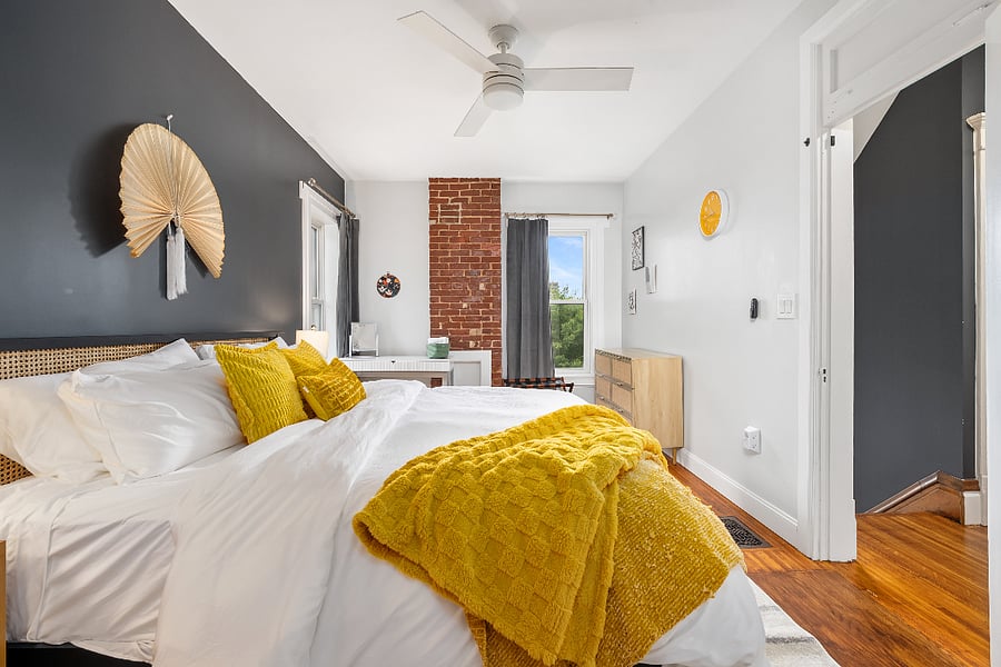 Primary bedroom with king size bed, en-suite bathroom, desk, dresser, and built in closets.