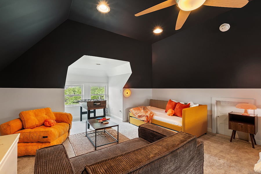 3rd Floor Attic with TV, lounge chairs and full bed. 600 sqft. Largest of the bedrooms and very quite.