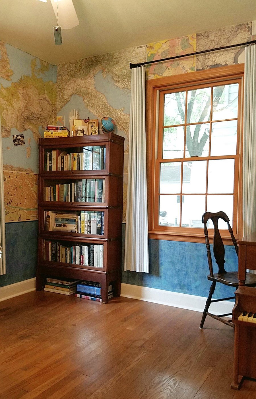 The guest room/Map Room (wallpapered with maps) features a twin Flexsteel sleeper sofa, antique barrister bookcase and a small desk and chair.