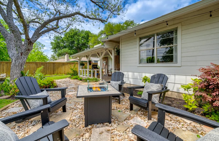 Outdoor Fire Pit with Adirondack chairs for a cozy evening under the garden lights and trees