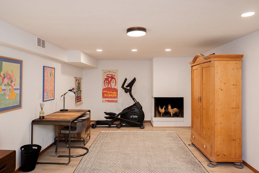 Designated office space with fireplace and elliptical exercise equipment
