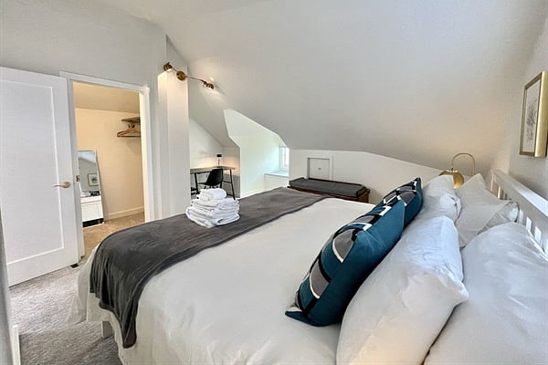 Relax in the spacious king bedroom with premium linens, AC, and desk!