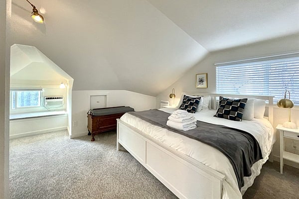 Relax in the spacious king bedroom with premium linens, AC, and desk!