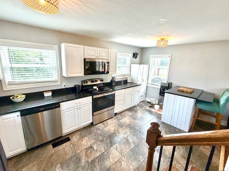 Full kitchen features stainless steel appliances, granite countertops, dishwasher, oven/stove top, microwave, fridge, pantry cabinet and island that also serves as a breakfast nook.