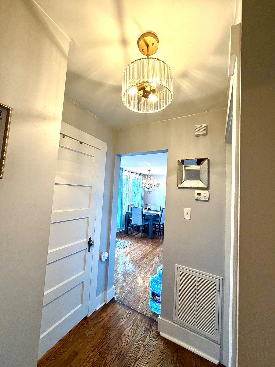 Hallway connecting the primary bedroom to the hall bath (door on left) and dining area.