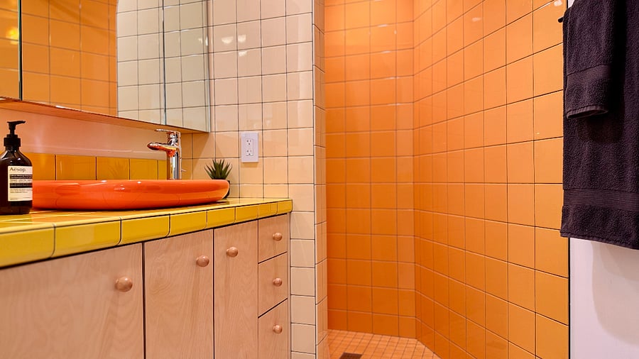 The bathroom features a spacious shower enclosure and colorful custom tile throughout.