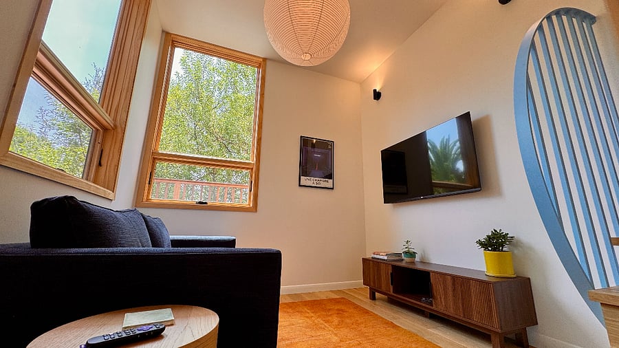 The living room features a 55-inch Roku 4K HD smart TV and the sofa converts into a queen-sized mattress.