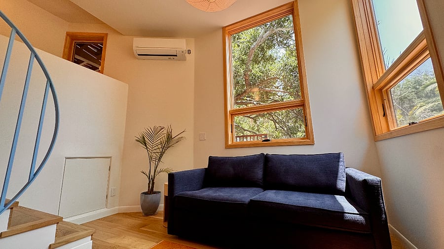 The living room features a 55-inch Roku 4K HD smart TV and the sofa converts into a queen-sized mattress.