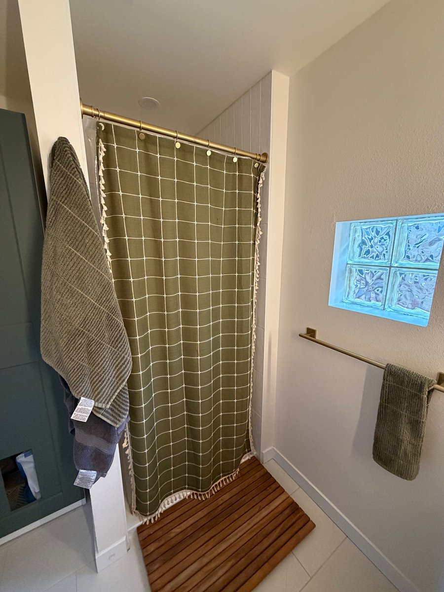 Primary Bathroom: Full bathroom with a spacious vanity and an additional freestanding storage cabinet, offering plenty of room for toiletries and personal items. The vanity also has space to tuck away a laundry hamper and, for guests traveling with a cat, a litter box.