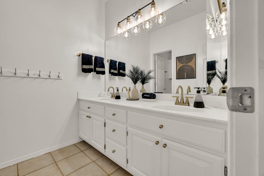 Second full bathroom with double sinks and separate tub/shower area.