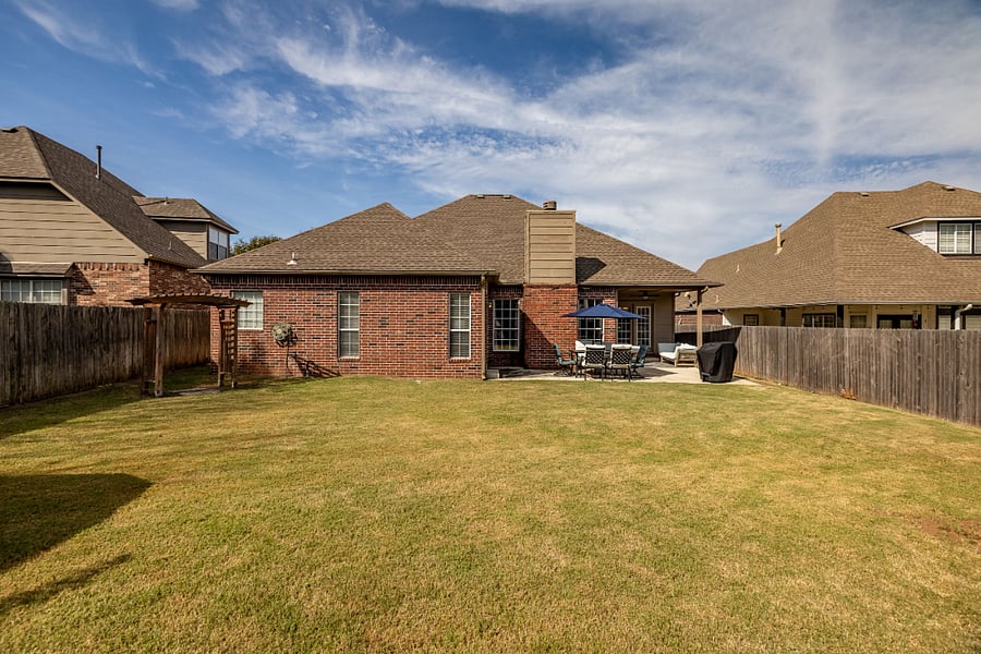Fenced-in back yard. Outdoor dining table and grill.
