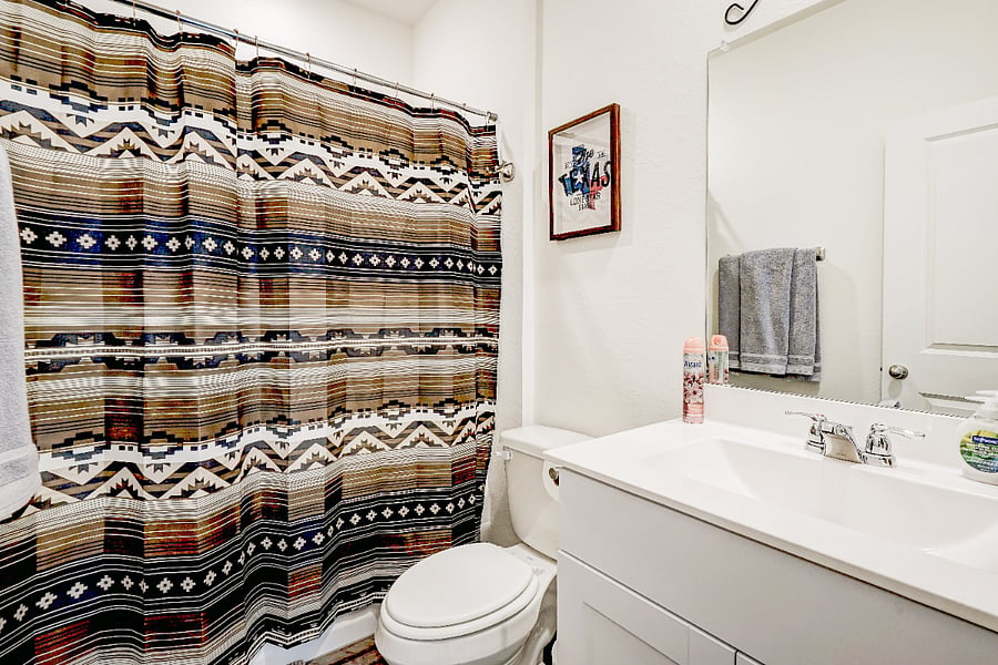 A convenient full restroom located right next to the downstairs king bedroom. Its stocked with all essential toiletries and starter amenities, providing comfort and easy access for guests staying on the main floor.