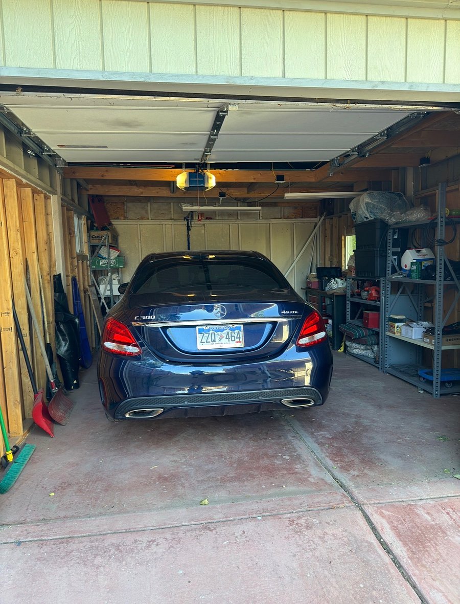 one car garage with tools and items including snow shovels, sleds, lawn chairs