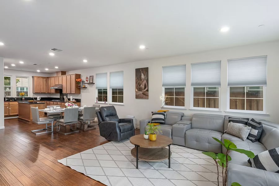 Living room featuring an L-shaped leather sofa with built-in recliners, a coffee table, TV, and an electric fireplace, creating a comfortable and inviting space for relaxation and entertainment.