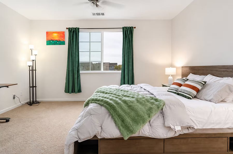 Bedroom #2  Spacious primary suite on the first floor with a California king bed, ensuite bathroom with walk-in closet, room-darkening curtains, and bedside lamps, creating a comfortable retreat for extended stays.