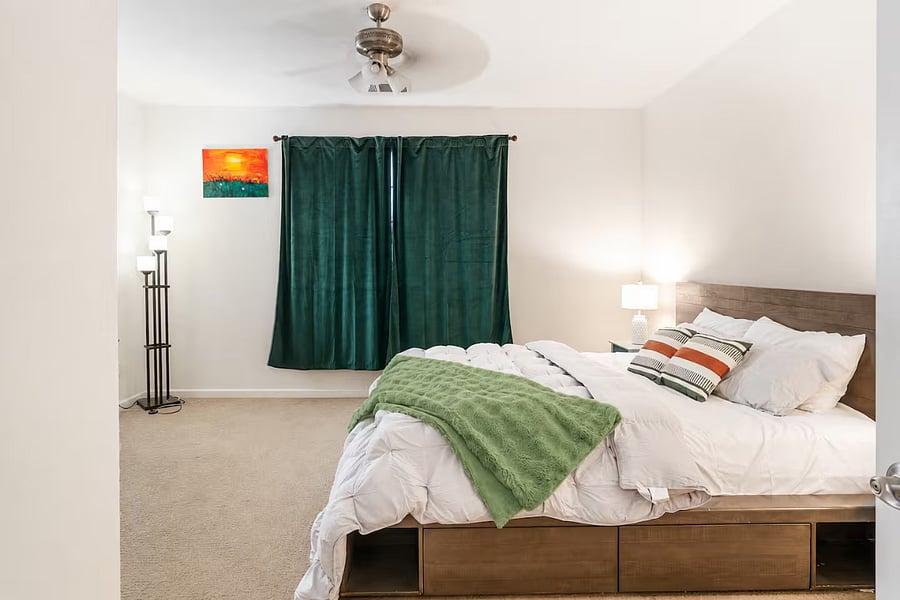 Bedroom #2  Spacious primary suite on the first floor with a California king bed, ensuite bathroom with walk-in closet, room-darkening curtains, and bedside lamps, creating a comfortable retreat for extended stays.