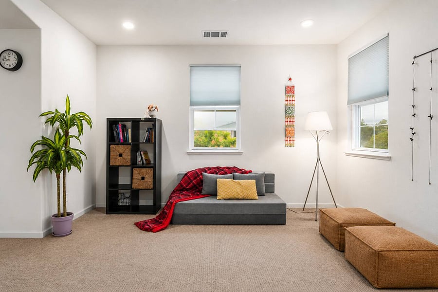 Spacious loft featuring a queen sofa-cum-bed for flexible use, cozy lounge seating, an eclectic bookshelf for relaxed reading, and ample closet storagedesigned for comfort, functionality, and everyday living.