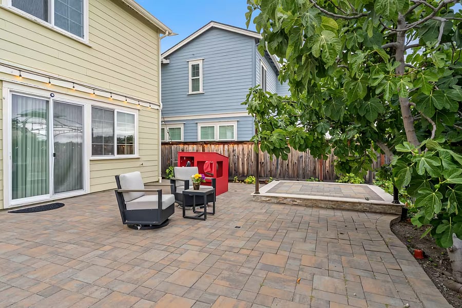 Private backyard with comfortable seating and mature fruit trees including lemon, peach, and figoffering a peaceful shaded space to relax and enjoy fresh, homegrown fruits.