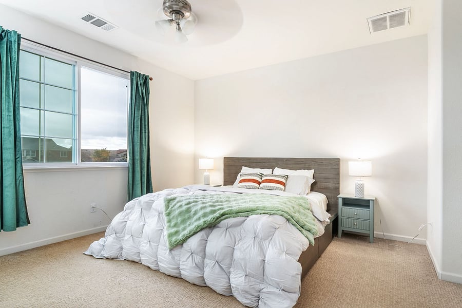 Bedroom #2 Spacious primary suite on the first floor with a California king bed, ensuite bathroom with walk-in closet, room-darkening curtains, and bedside lamps, creating a comfortable retreat for extended stays.