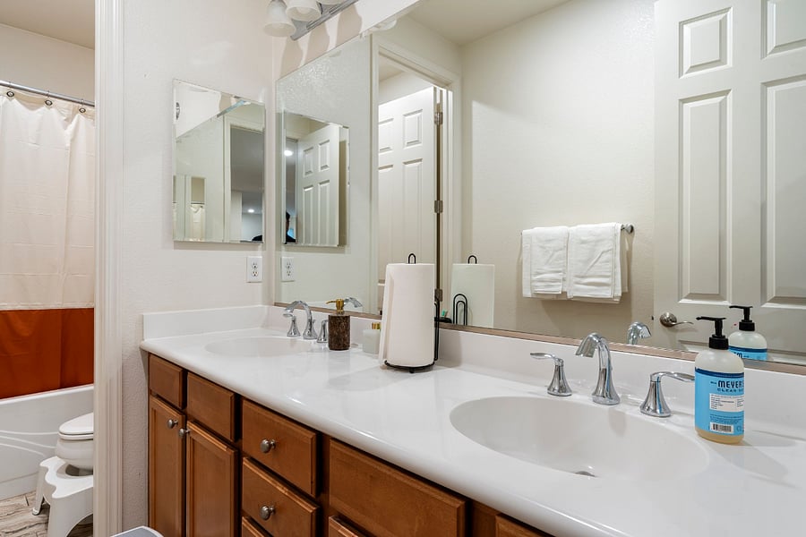 Bathroom #3  Shared bathroom between the kids room and workspace room, featuring a bathtub, double vanity, and a privacy curtain for added convenience.