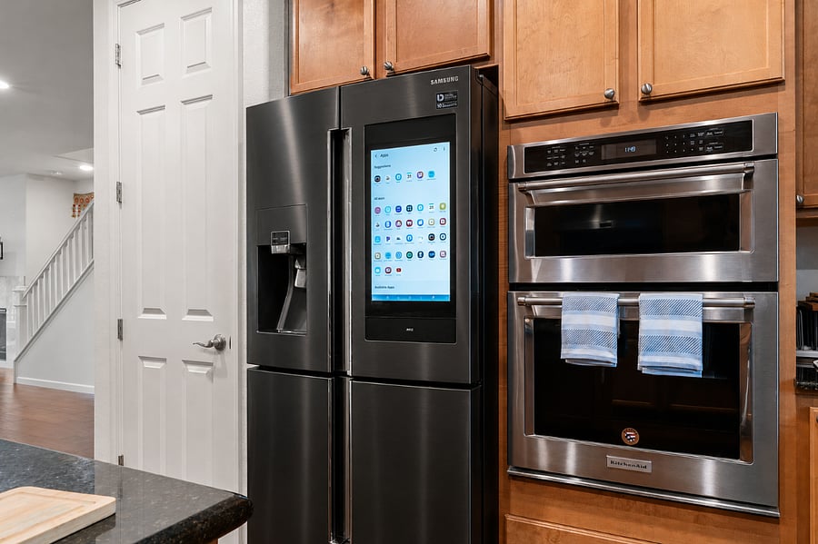 Gourmet kitchen featuring an island and premium KitchenAid appliances, including a microwave, oven, and dishwasher. A smart refrigerator adds modern convenience, making this kitchen both stylish and highly functional for everyday cooking and entertaining.