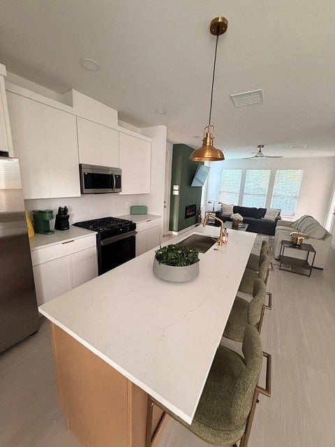 Modern chef kitchen stocked with cooking essentials and dishware/glassware