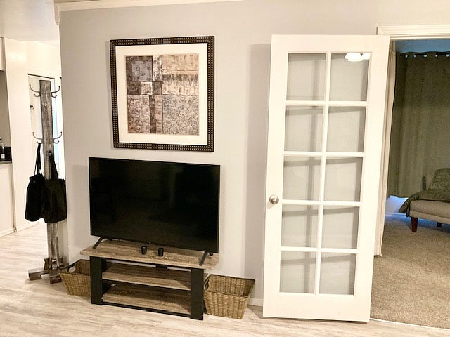 Smart TV and French doors that lead to the walk-in closet and bedroom