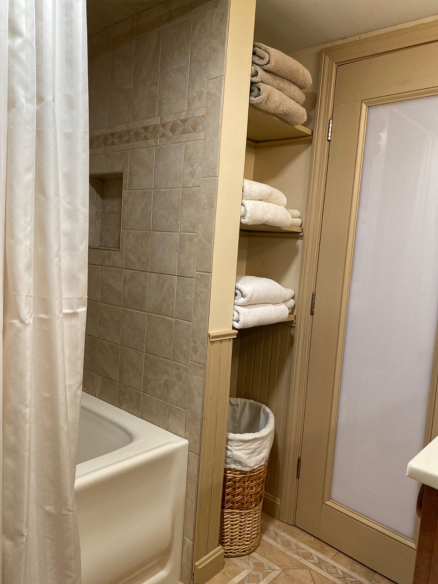 full bathroom second view with storage nook for towels and laundry hamper