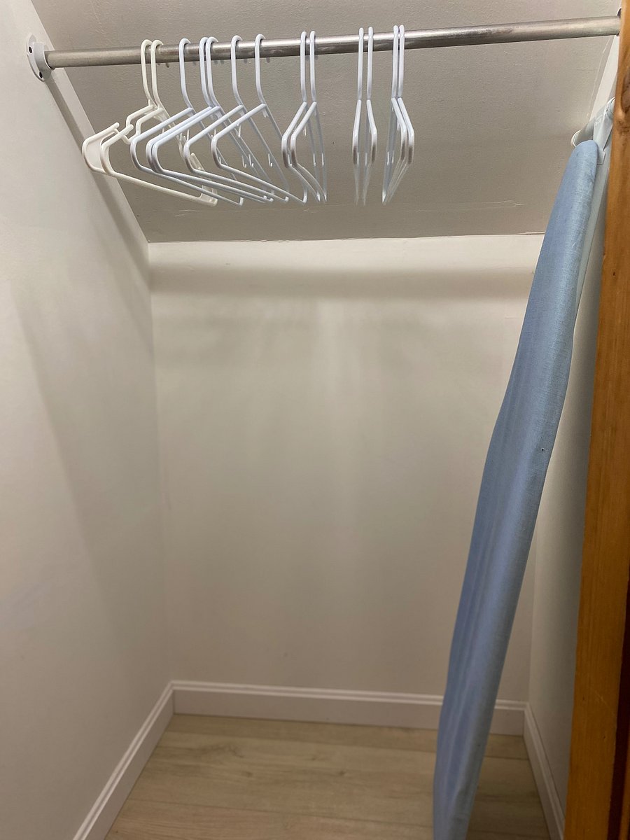 one of 3 closets with ironing board and hangers