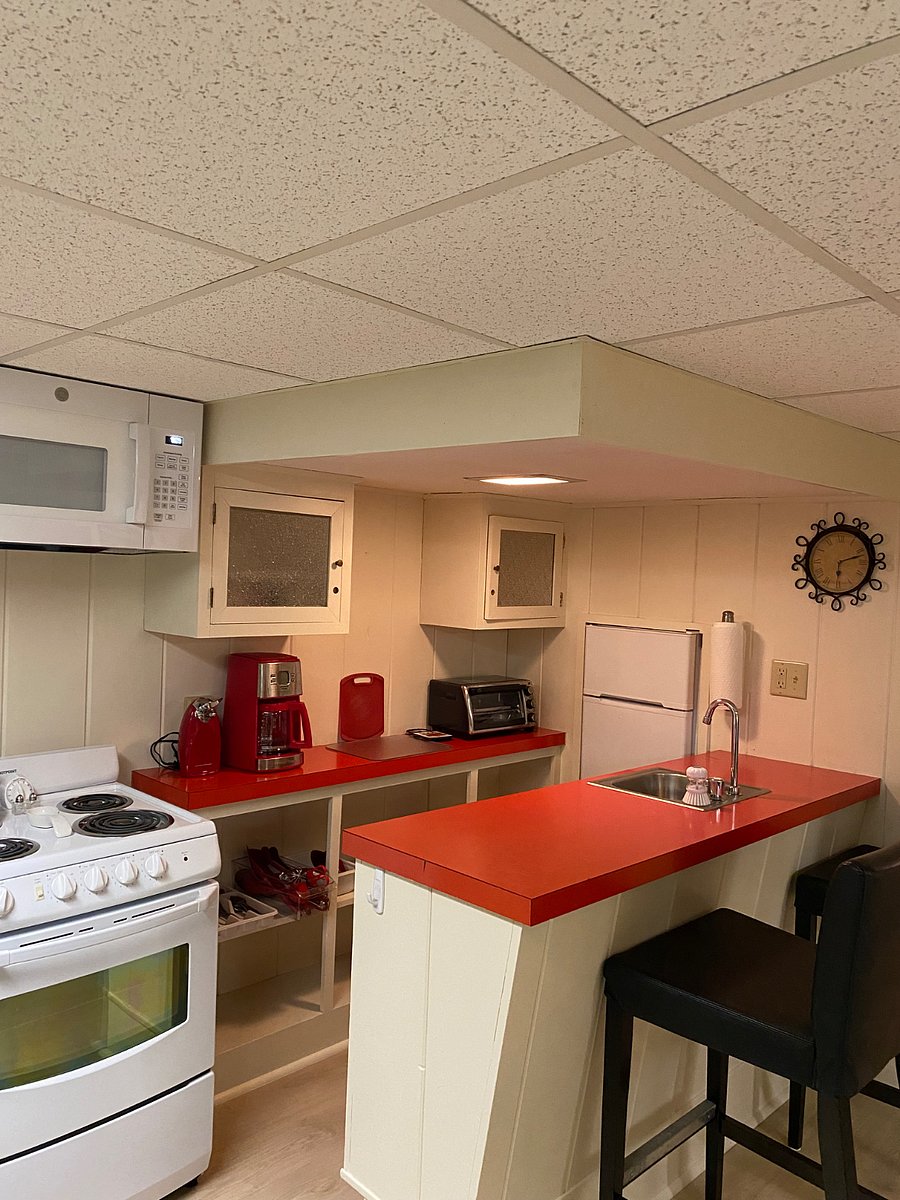 kitchen with microwave, range, coffee maker, can opener, toaster oven, mini fridge, dishes, flatware, cooking utensils and cookware,
