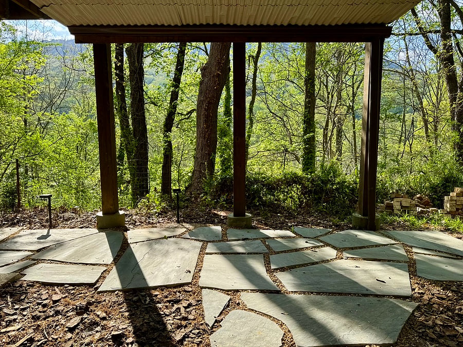 Covered flagstone walkway by apartment entrance.