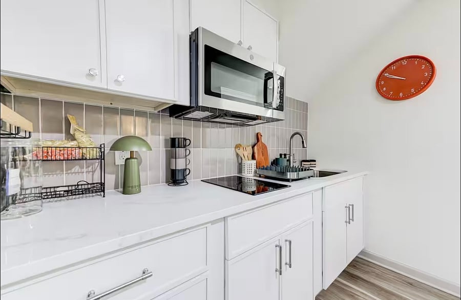 The kitchenette includes a induction cooktop, microwave,sink, full size refrigerator, coffee maker with complimentary coffee, toaster, pots, pans, dishes utensils, cups, bowls, and drying rack 

